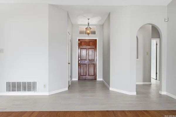 a view of a hallway with wooden floor and a cabinet