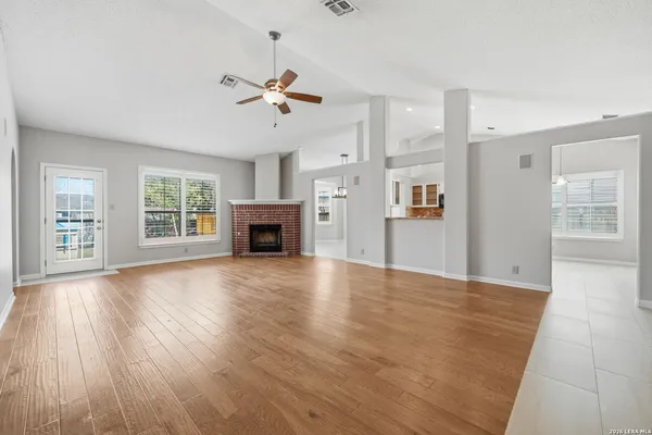 a view of empty room with wooden floor and window