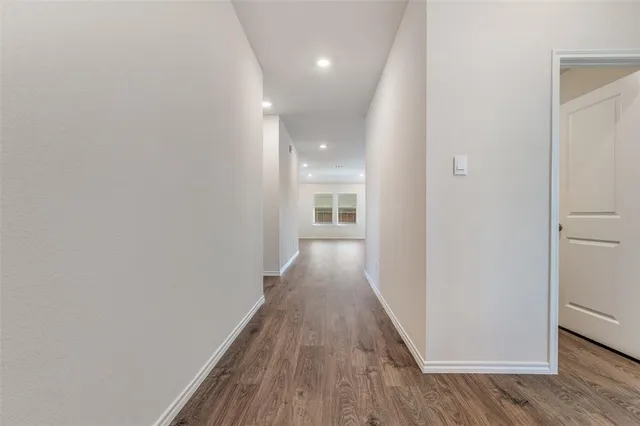 a view of a hallway with wooden floor