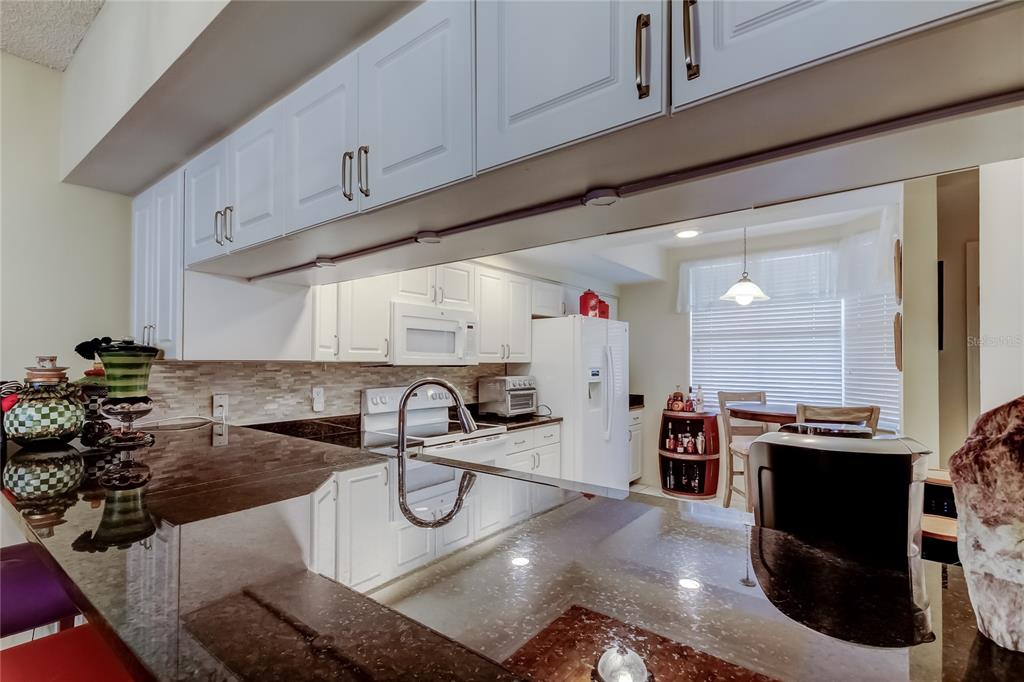 6205 Shoreline Drive, Unit 1304 Seminole, FL 33708 - Photo 11 of 57 a kitchen with a sink a stove and cabinets