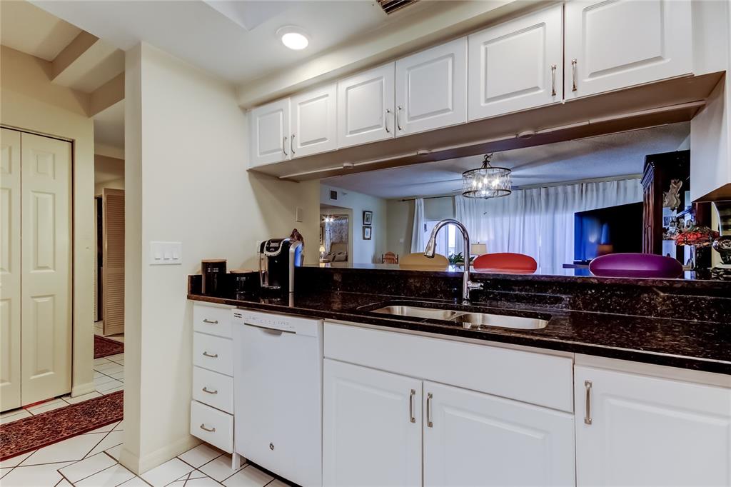 6205 Shoreline Drive, Unit 1304 Seminole, FL 33708 - Photo 12 of 57 a kitchen with stainless steel appliances granite countertop a sink and cabinets