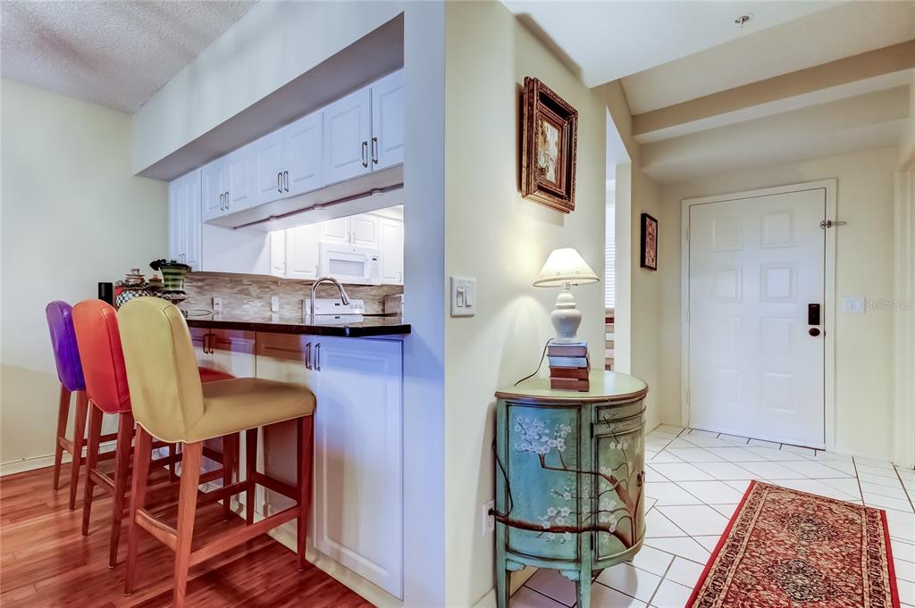 6205 Shoreline Drive, Unit 1304 Seminole, FL 33708 - Photo 15 of 57 a dining room with furniture and wooden floor