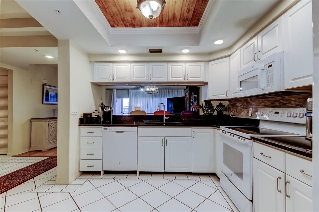 6205 Shoreline Drive, Unit 1304 Seminole, FL 33708 - Photo 4 of 57 a kitchen with granite countertop a sink and cabinets