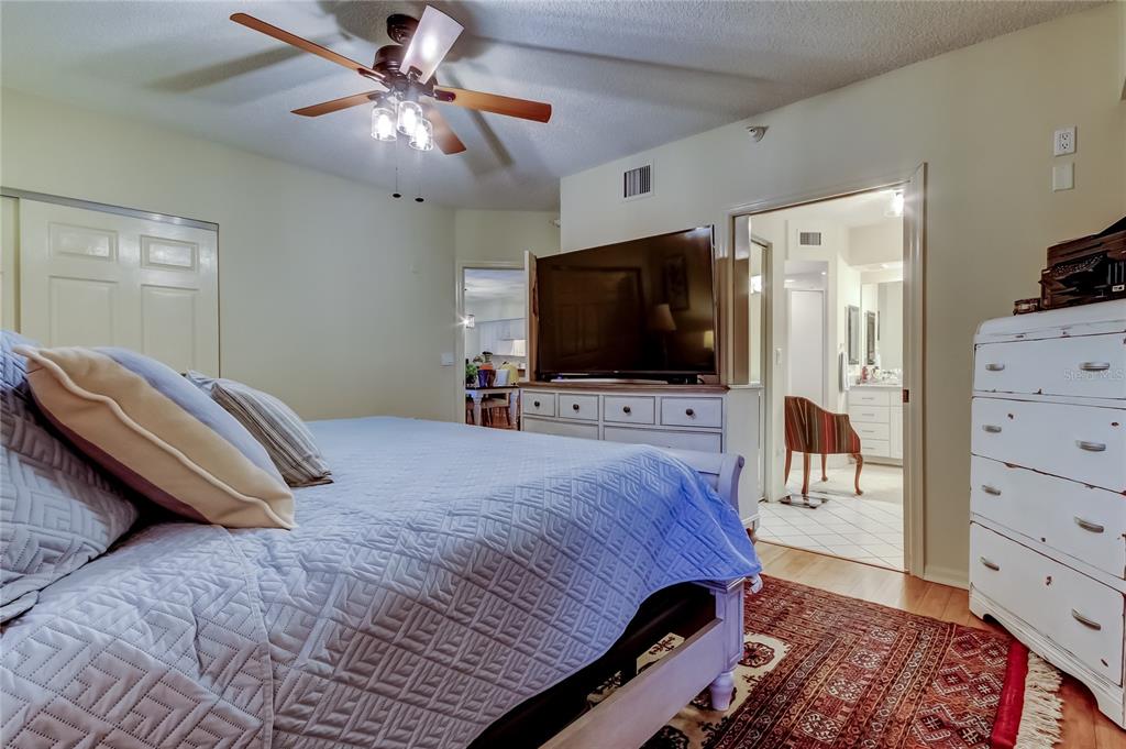 6205 Shoreline Drive, Unit 1304 Seminole, FL 33708 - Photo 41 of 57 a bedroom with a bed and a flat tv screen on dresser