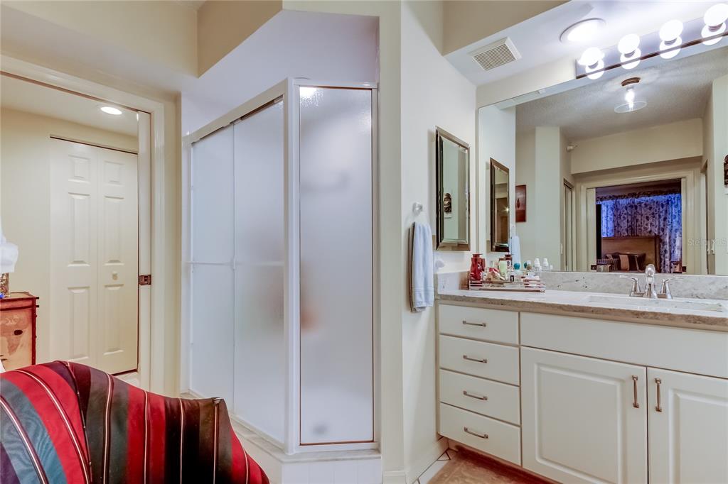 6205 Shoreline Drive, Unit 1304 Seminole, FL 33708 - Photo 42 of 57 a en suite bathroom with a double vanity sink a mirror and a shower