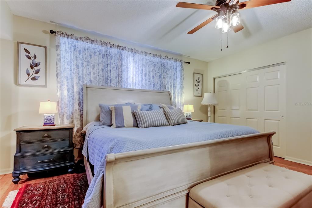 6205 Shoreline Drive, Unit 1304 Seminole, FL 33708 - Photo 44 of 57 a bedroom with a bed and a chandelier