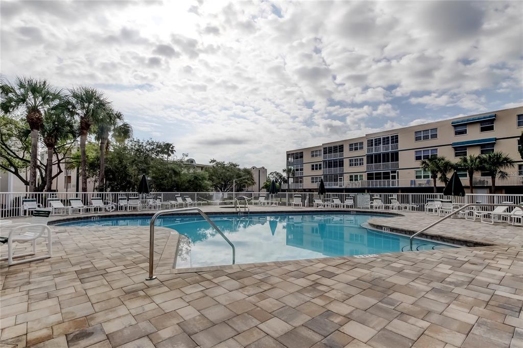 6205 Shoreline Drive, Unit 1304 Seminole, FL 33708 - Photo 51 of 57 a view of a swimming pool with a lounge chairs
