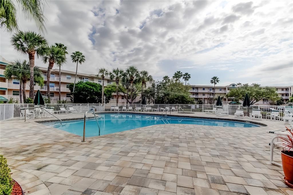 6205 Shoreline Drive, Unit 1304 Seminole, FL 33708 - Photo 52 of 57 a view of a swimming pool with a lounge chairs