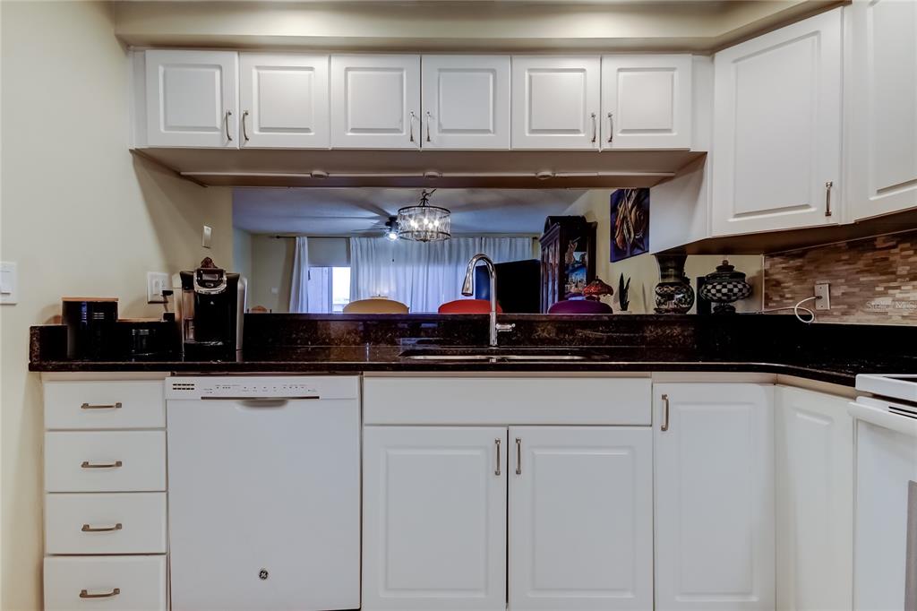 6205 Shoreline Drive, Unit 1304 Seminole, FL 33708 - Photo 7 of 57 a kitchen with stainless steel appliances granite countertop a sink and cabinets