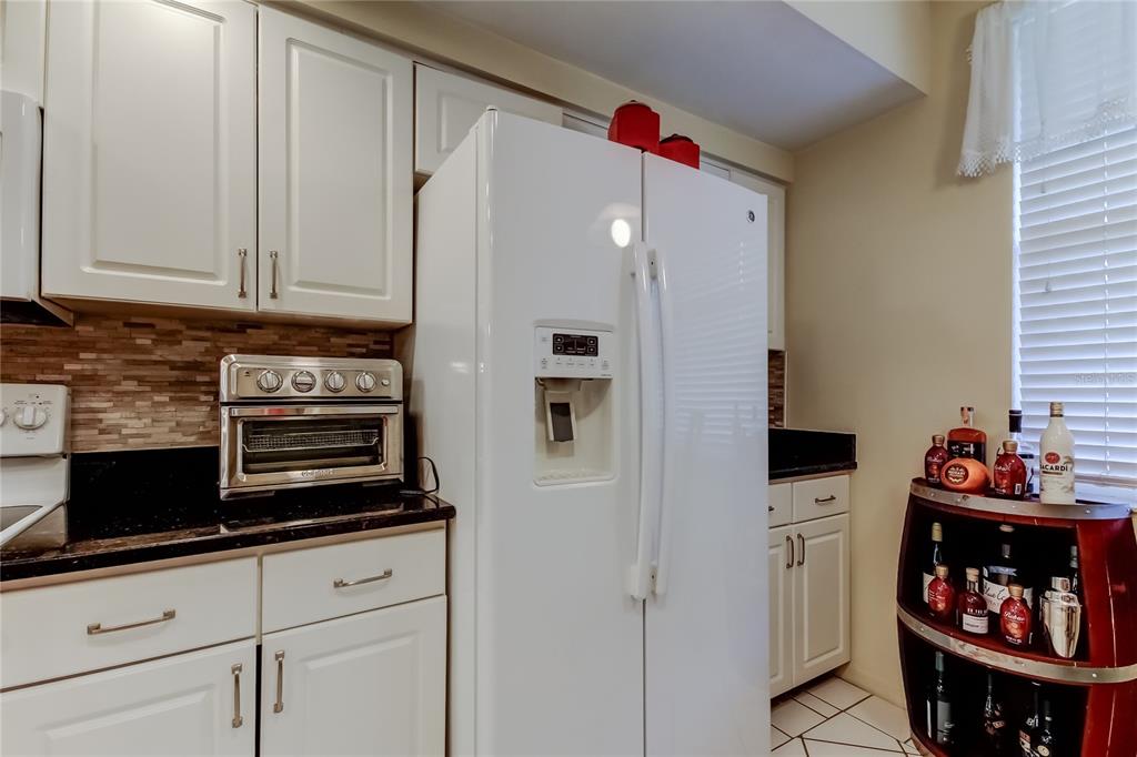 6205 Shoreline Drive, Unit 1304 Seminole, FL 33708 - Photo 9 of 57 a kitchen with stainless steel appliances white cabinets and a refrigerator
