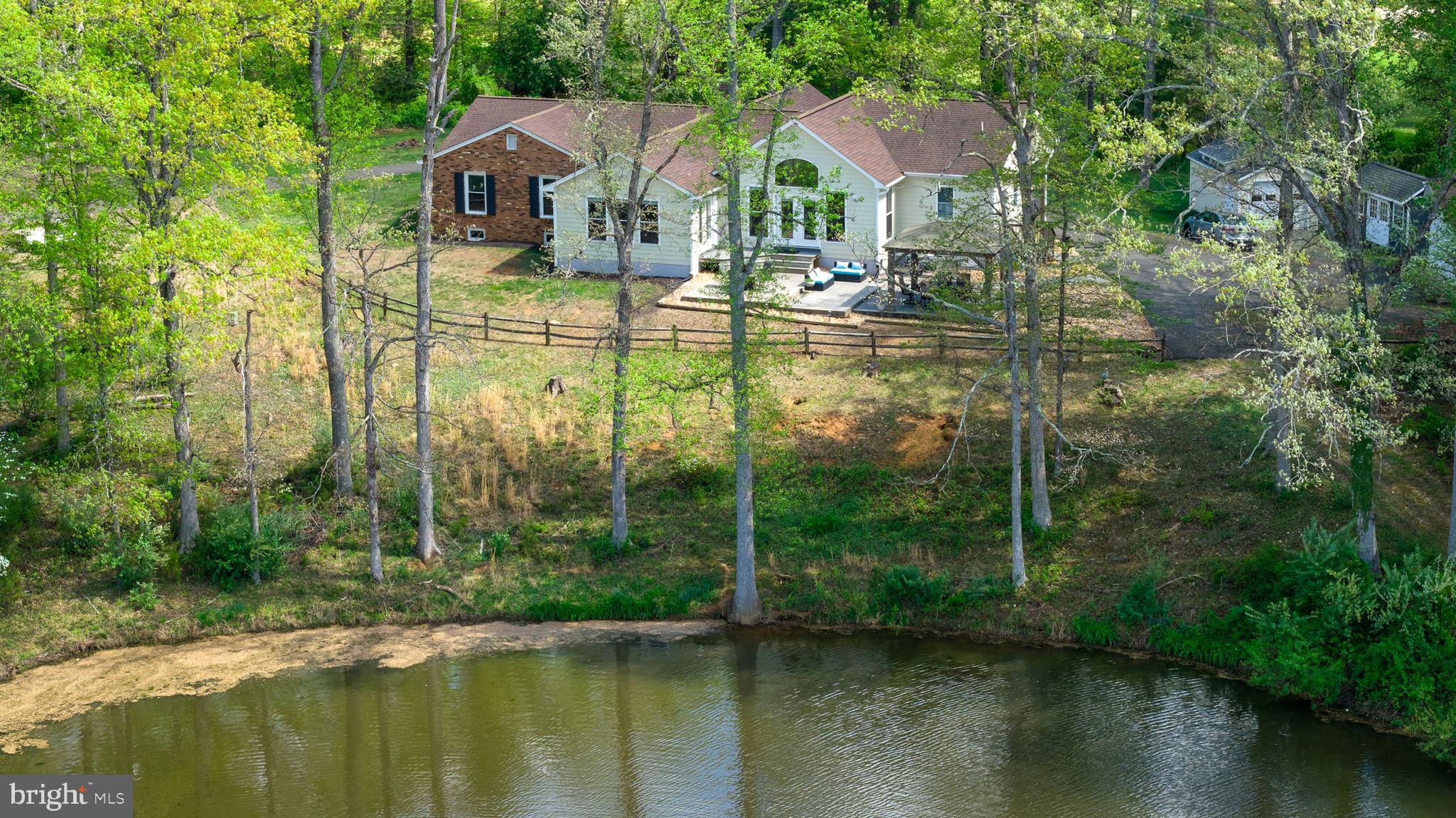 5699 Red Brick Road Warrenton, VA 20187 - Photo 1 of 35 Serene lakeside retreat in lush greenery.