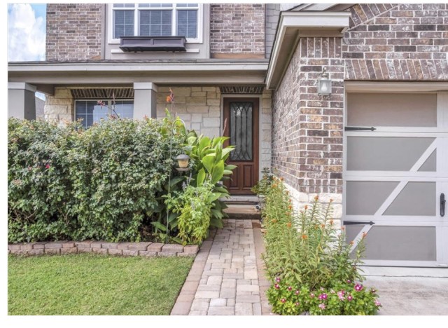 Doorway to property featuring stone siding and brick siding