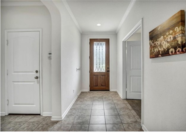 1428 Crested Butte Way Georgetown, TX 78626 - Photo 2 of 28 Entryway featuring crown molding, light tile patterned flooring, and arched walkways