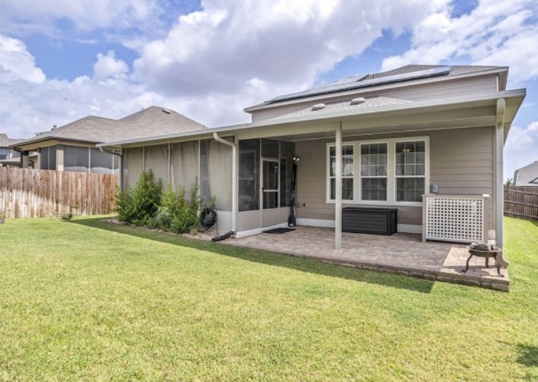 1428 Crested Butte Way Georgetown, TX 78626 - Photo 25 of 28 Back of property with a fenced backyard, solar panels, a sunroom, and a patio