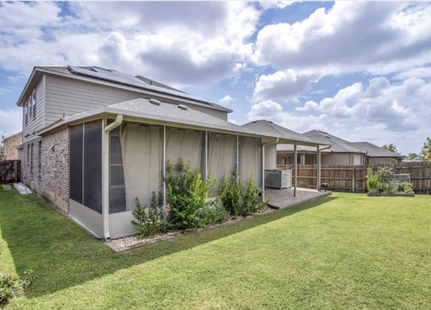 1428 Crested Butte Way Georgetown, TX 78626 - Photo 27 of 28 Back of property with brick siding, a fenced backyard, and roof mounted solar panels