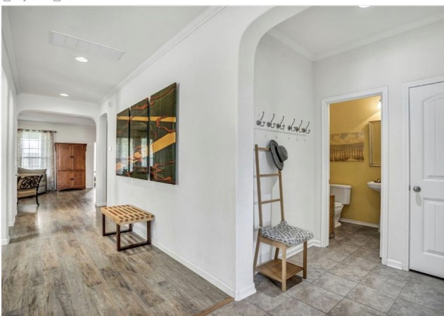 1428 Crested Butte Way Georgetown, TX 78626 - Photo 3 of 28 Hall with arched walkways, ornamental molding, recessed lighting, and light wood-style floors