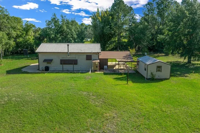 a view of a house with a backyard and a patio