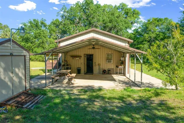 a view of a chair and table in backyard of the house