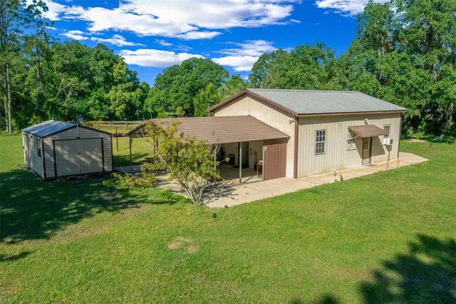 a view of a house with backyard and sitting area