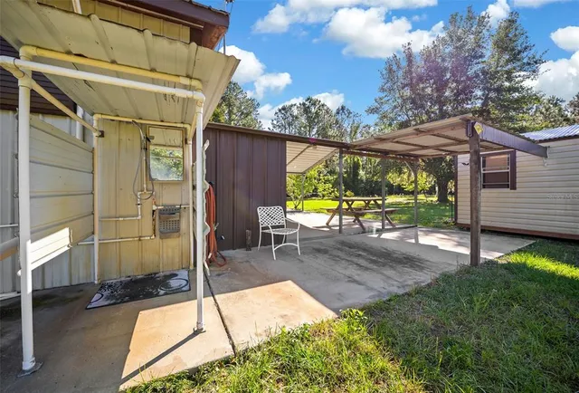a view of a chair and table in backyard of the house