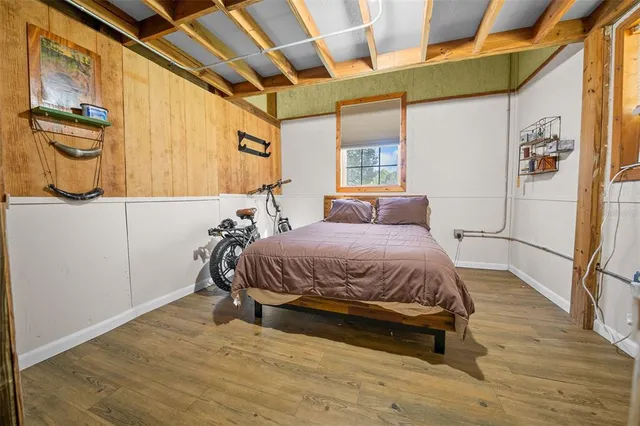 a bedroom with a bed and wooden floor
