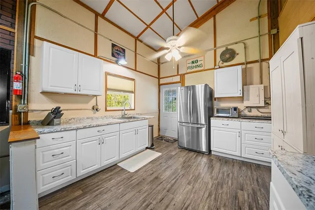 a kitchen with stainless steel appliances granite countertop a refrigerator and wooden cabinets