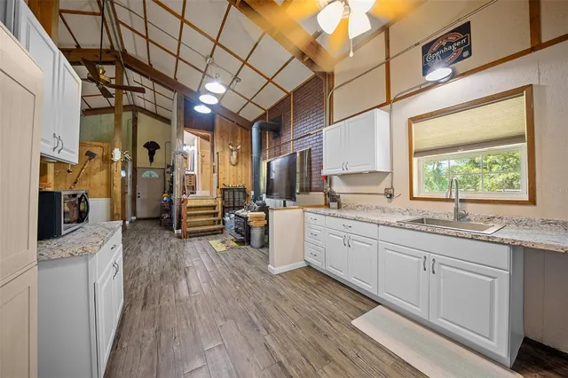 a large kitchen with a lot of counter space and wooden floor