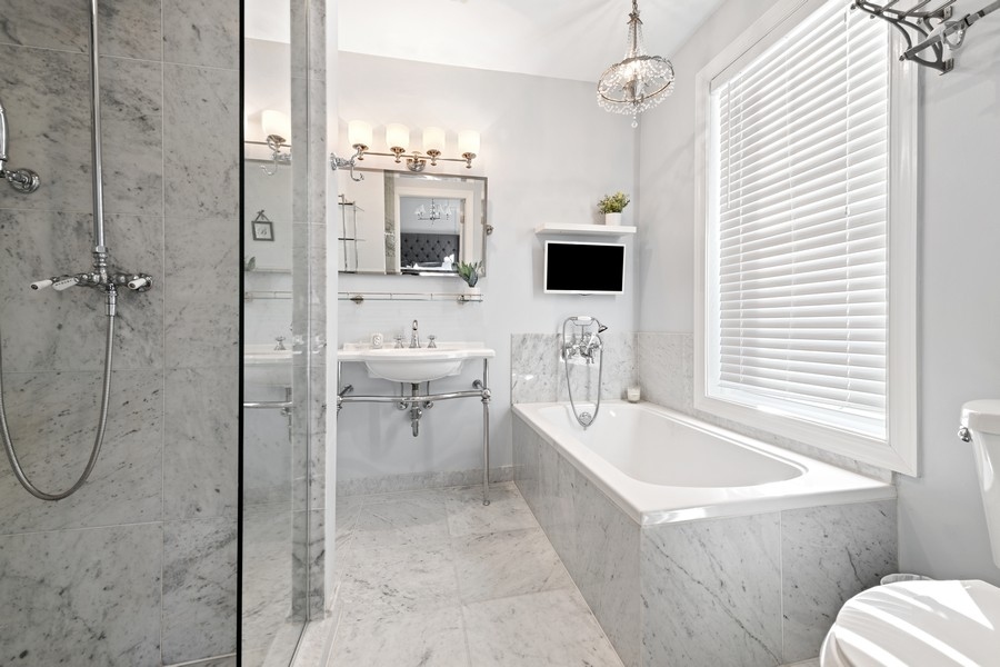 3721 North Racine Avenue Chicago, IL 60613 - Photo 16 of 28 a bathroom with a tub a sink and a window
