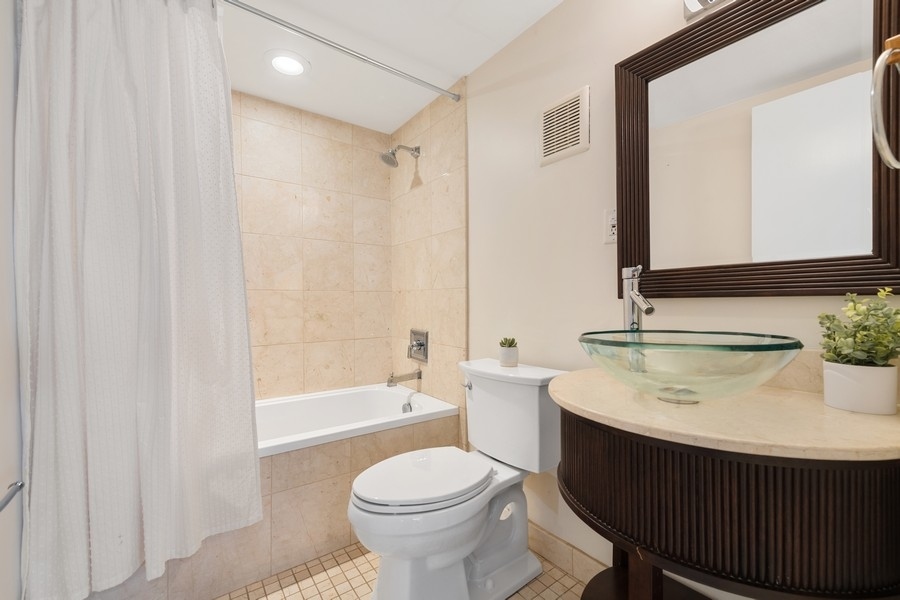 3721 North Racine Avenue Chicago, IL 60613 - Photo 22 of 28 a bathroom with a sink toilet a mirror and shower