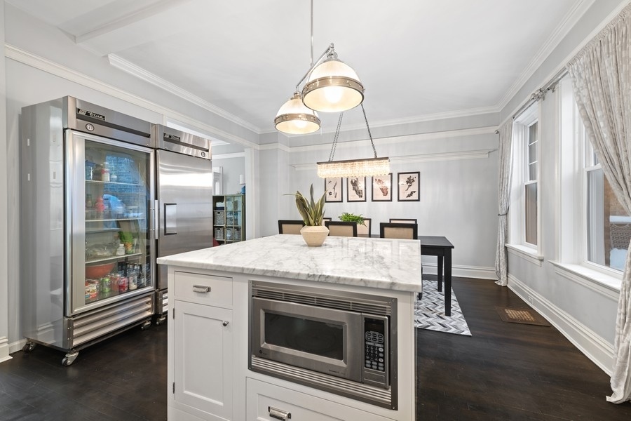 3721 North Racine Avenue Chicago, IL 60613 - Photo 7 of 28 a kitchen with a stove a refrigerator and a table