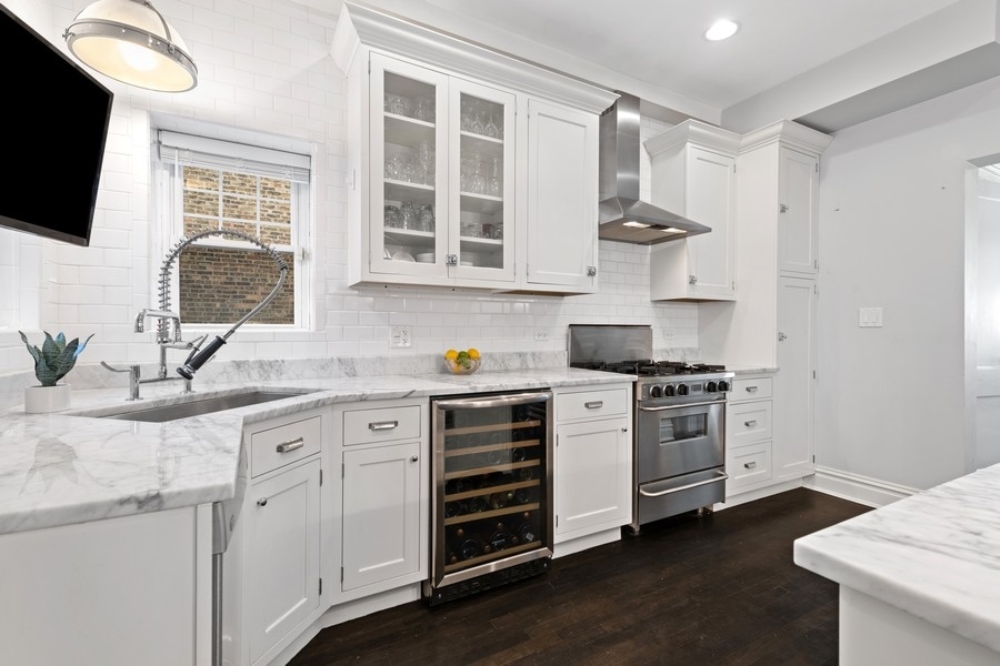 3721 North Racine Avenue Chicago, IL 60613 - Photo 8 of 28 a kitchen with stainless steel appliances granite countertop a stove and a sink