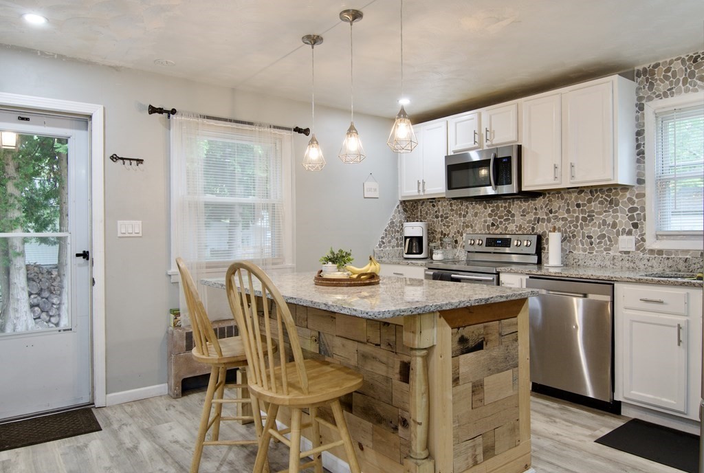 37 Greaney Street Springfield, MA 01104 - Photo 9 of 40 a kitchen with stainless steel appliances granite countertop a sink a stove a table and chairs