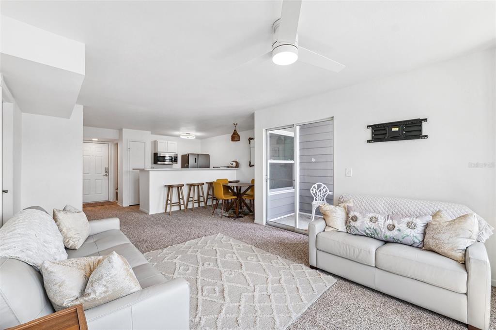 5712 Biscayne Court, Unit 103 New Port Richey, FL 34652 - Photo 13 of 31 a living room with furniture and a flat screen tv