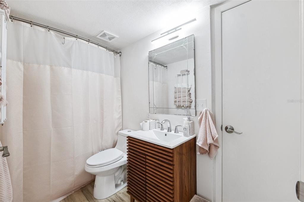 5712 Biscayne Court, Unit 103 New Port Richey, FL 34652 - Photo 15 of 31 a bathroom with a sink a toilet and shower curtain