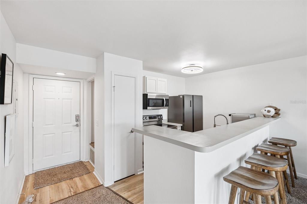5712 Biscayne Court, Unit 103 New Port Richey, FL 34652 - Photo 6 of 31 a kitchen with stainless steel appliances a refrigerator and a stove