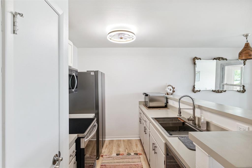 5712 Biscayne Court, Unit 103 New Port Richey, FL 34652 - Photo 7 of 31 a kitchen with stainless steel appliances granite countertop a sink and a stove