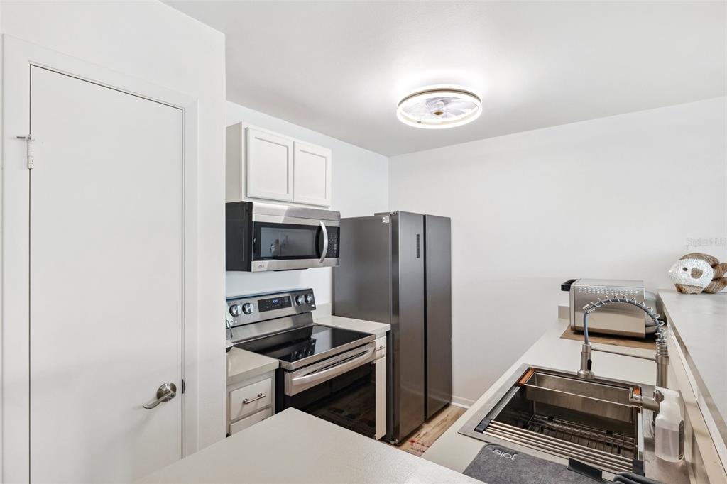 5712 Biscayne Court, Unit 103 New Port Richey, FL 34652 - Photo 8 of 31 a kitchen with a refrigerator and a stove top oven