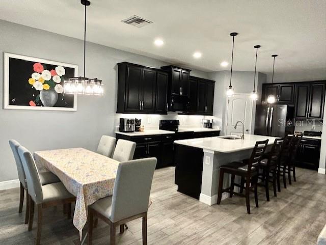 13850 Moosehead Circle Hudson, FL 34669 - Photo 17 of 71 a kitchen with a dining table chairs and refrigerator