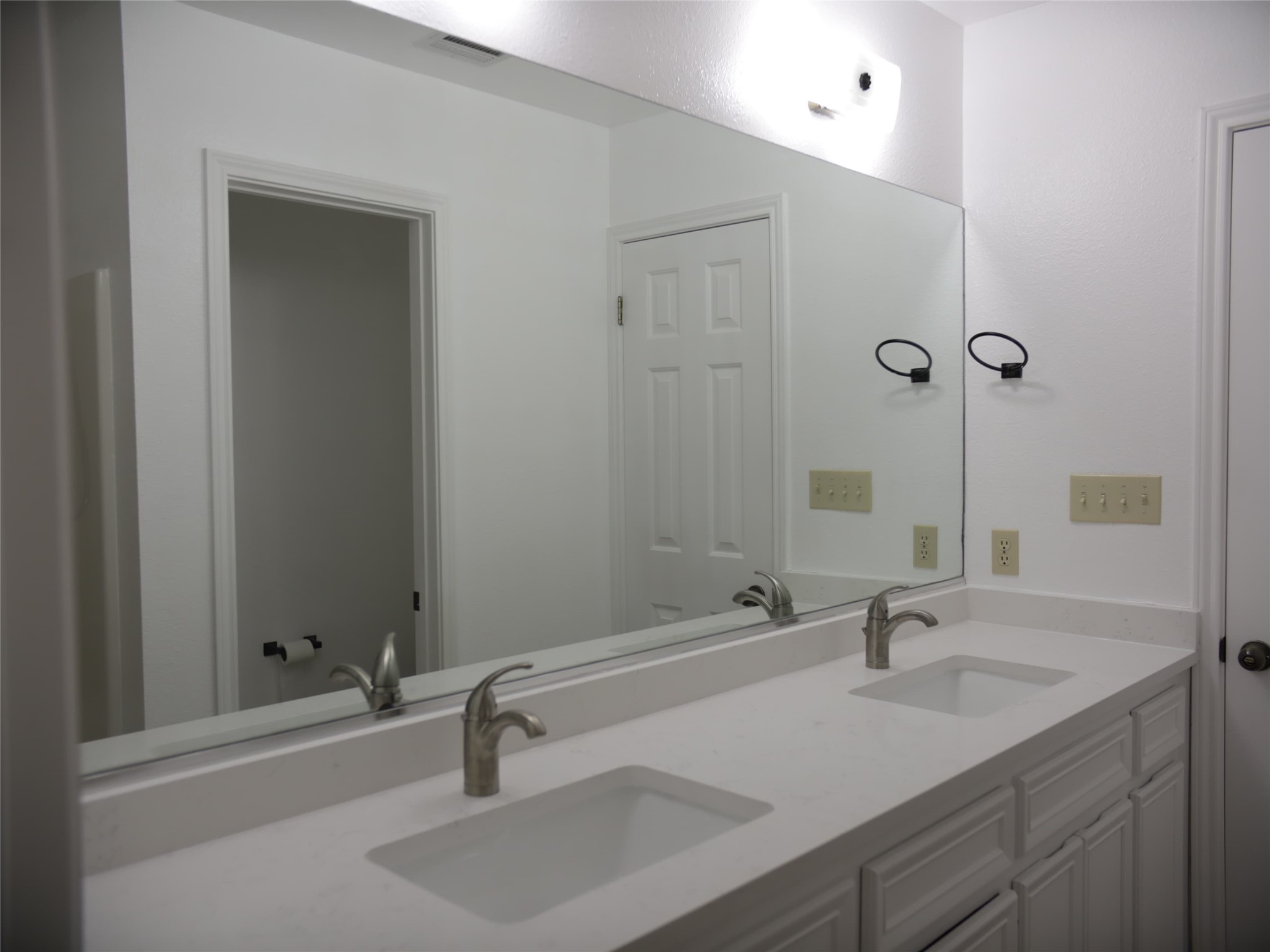 1612 Buttercup Road Pflugerville, TX 78660 - Photo 10 of 16 Double vanities and an expansive mirror elevate this well-appointed primary bathroom.