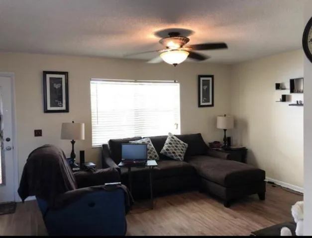 a living room with furniture a large window and a chandelier