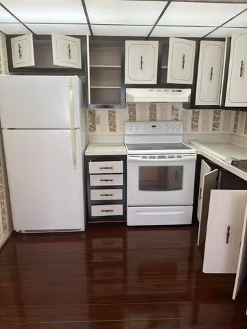 a kitchen with stainless steel appliances a refrigerator a stove and white cabinets