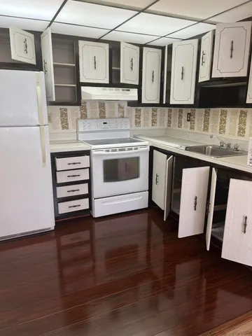 a kitchen with stainless steel appliances granite countertop a stove and white cabinets