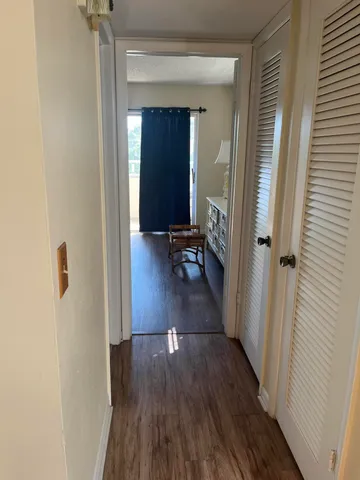 a view of a hallway with wooden floor and stairs
