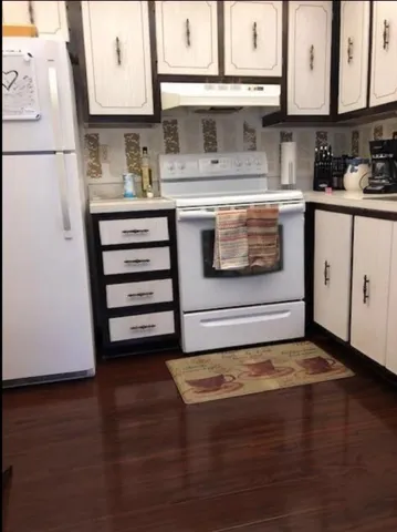 a kitchen with granite countertop a stove and cabinets