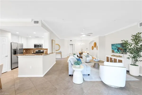 a living room with kitchen island furniture and a kitchen view