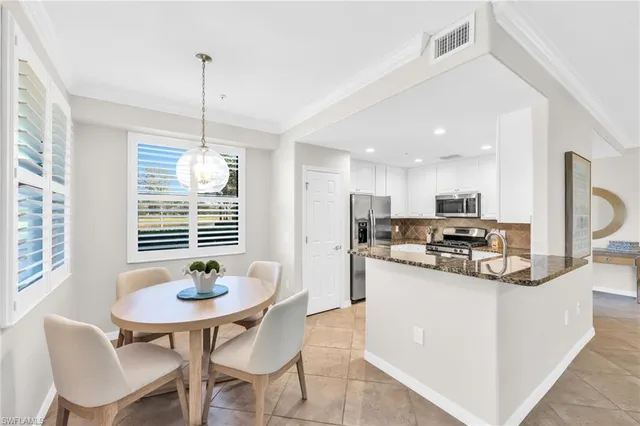 a kitchen with stainless steel appliances kitchen island granite countertop a dining table and chairs