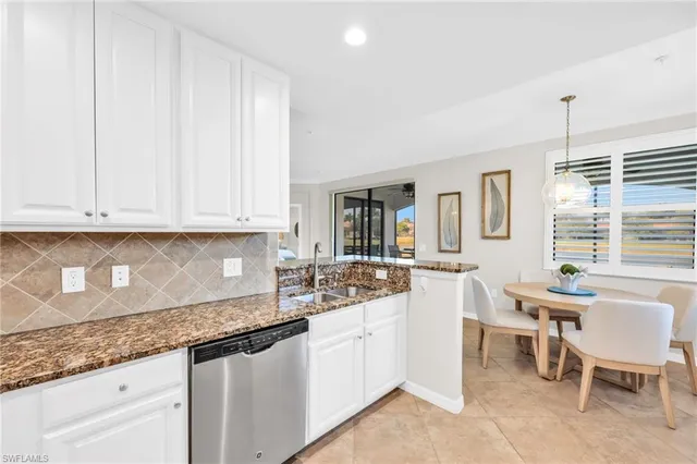 a kitchen with granite countertop white cabinets and white appliances