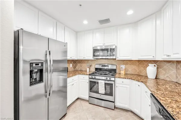 a kitchen with cabinets and stainless steel appliances
