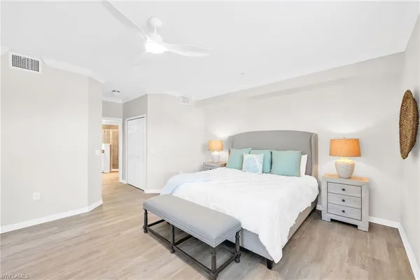 a bedroom with a large bed and wooden floor