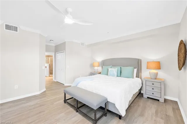 a bedroom with a large bed and wooden floor